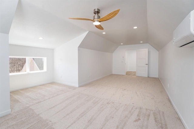 additional living space with a wall unit AC, baseboards, lofted ceiling, and carpet