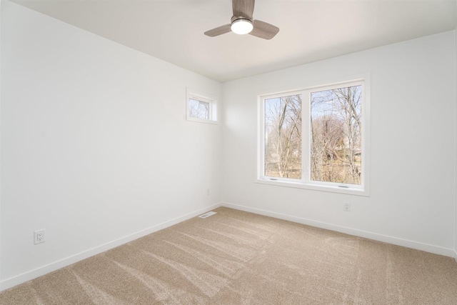 carpeted empty room with ceiling fan, baseboards, and visible vents