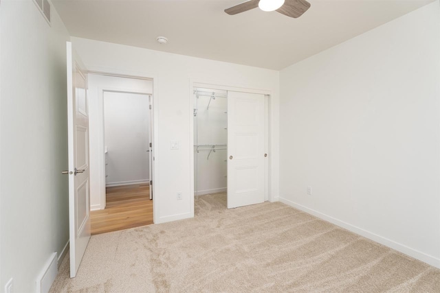 unfurnished bedroom featuring ceiling fan, carpet, a closet, visible vents, and baseboards