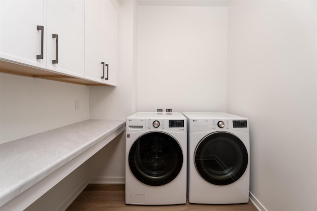 washroom with cabinet space, baseboards, light wood finished floors, and separate washer and dryer