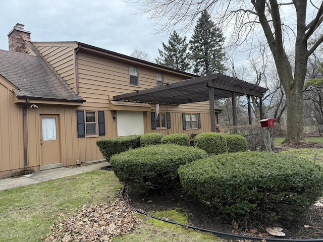 back of property featuring board and batten siding, a pergola, and a chimney