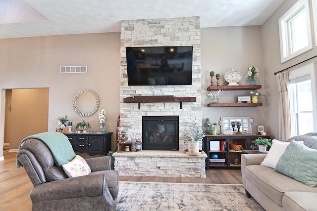 1817 Arboretum Dr, Janesville, WI 53548 - living room featuring a fireplace, a towering ceiling, visible vents, and wood finished floors
