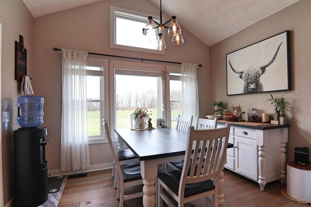 1817 Arboretum Dr, Janesville, WI 53548 - dining room featuring a chandelier, hardwood / wood-style floors, lofted ceiling, and plenty of natural light