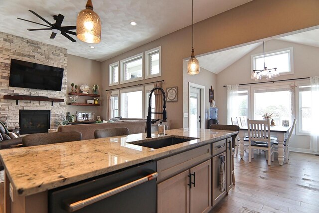 1817 Arboretum Dr, Janesville, WI 53548 - kitchen with a fireplace, dishwashing machine, a sink, open floor plan, and light wood finished floors