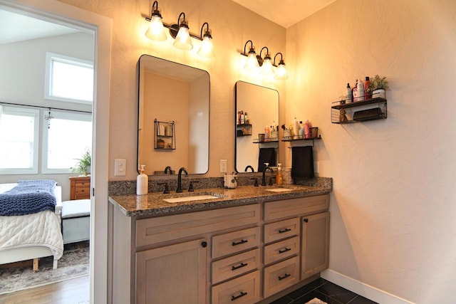 1817 Arboretum Dr, Janesville, WI 53548 - bathroom featuring a sink, baseboards, double vanity, and ensuite bath