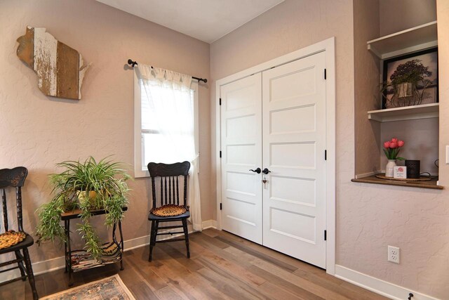 1817 Arboretum Dr, Janesville, WI 53548 - sitting room featuring a textured wall, baseboards, and wood finished floors