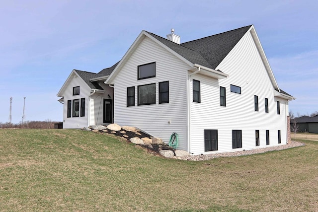 1817 Arboretum Dr, Janesville, WI 53548 - view of front of house featuring roof with shingles, a chimney, and a front lawn