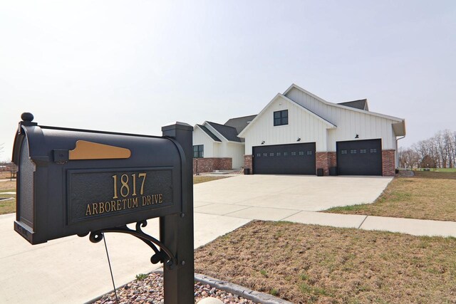 1817 Arboretum Dr, Janesville, WI 53548 - exterior details featuring board and batten siding, concrete driveway, and brick siding