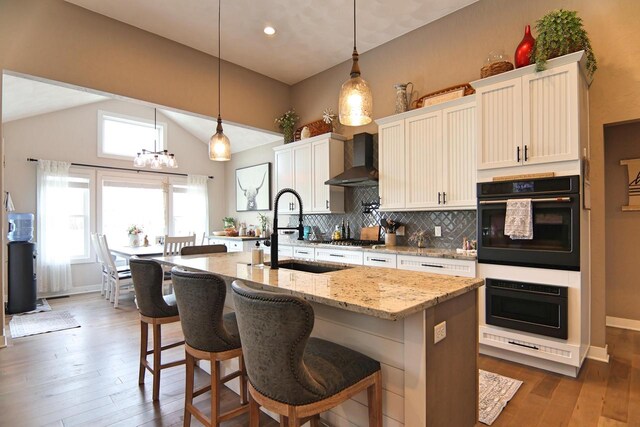 1817 Arboretum Dr, Janesville, WI 53548 - kitchen with a sink, wall chimney range hood, wood-type flooring, a chandelier, and backsplash