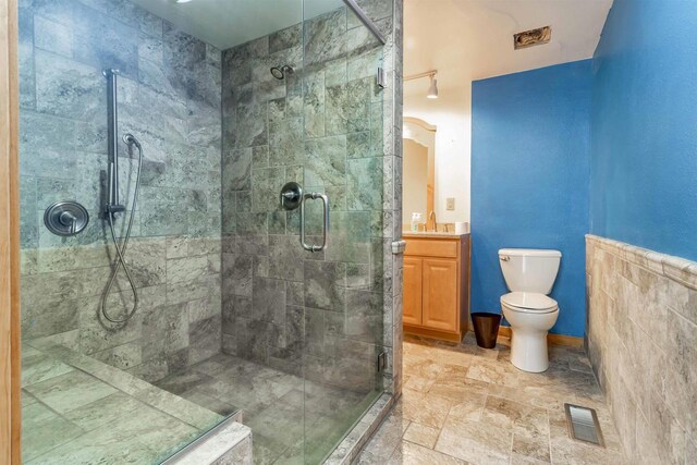 N10368 Queens Way Way, Necedah, WI 54646 - bathroom with visible vents, toilet, stone finish floor, a shower stall, and vanity