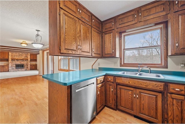 kitchen featuring a peninsula, a sink, open floor plan, light wood-style floors, and dishwasher