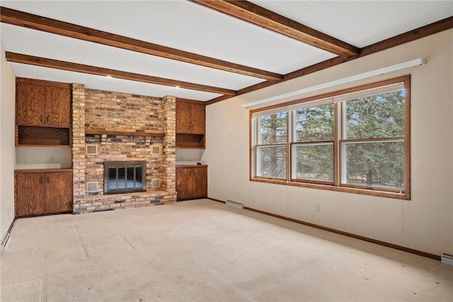 unfurnished living room featuring visible vents, beam ceiling, carpet flooring, and a healthy amount of sunlight