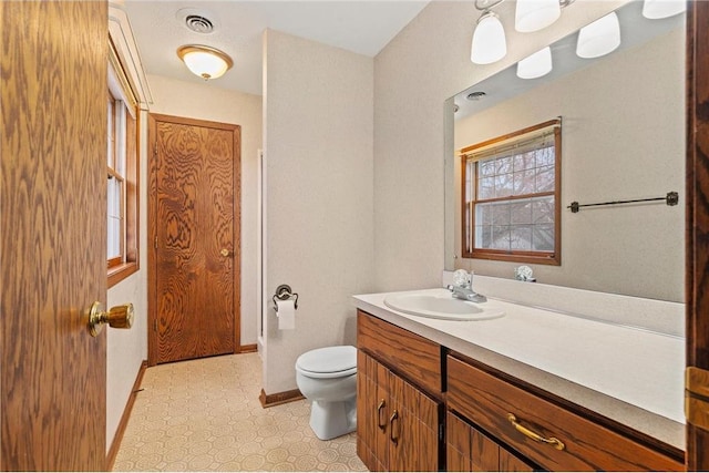 bathroom with tile patterned floors, visible vents, toilet, vanity, and baseboards