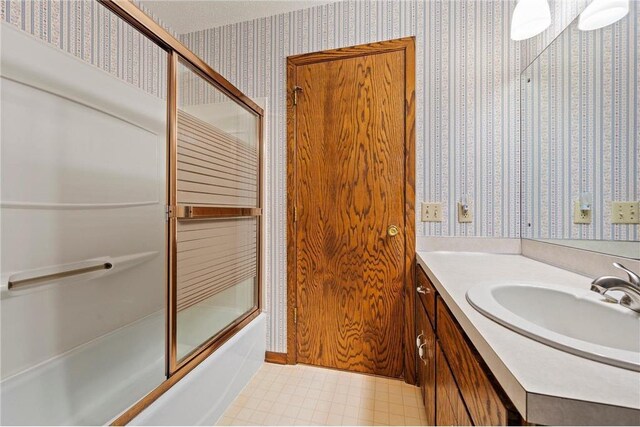 full bath with wallpapered walls, vanity, tile patterned floors, and enclosed tub / shower combo