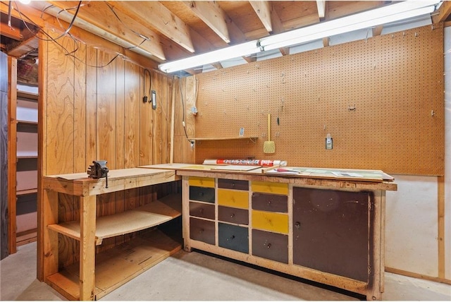 unfinished below grade area with wooden walls and a workshop area