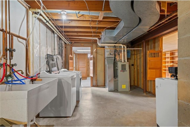 unfinished below grade area with heating unit and washer and clothes dryer