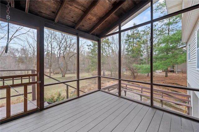 unfurnished sunroom with beam ceiling and a healthy amount of sunlight