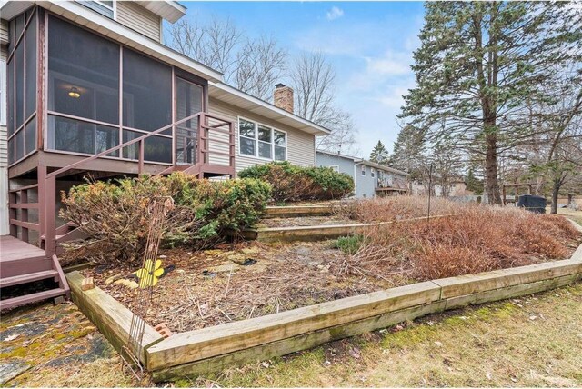 view of home's exterior with a chimney and a sunroom