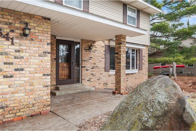 doorway to property with brick siding