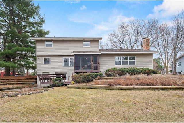 back of house featuring a sunroom, a chimney, and a lawn