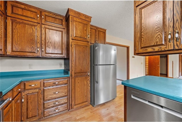 kitchen featuring brown cabinets, light wood-style flooring, and stainless steel appliances