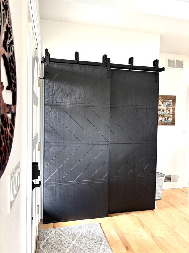 W330S8380 Isabelle Dr, Mukwonago, WI 53149 - details featuring visible vents, a barn door, and wood finished floors