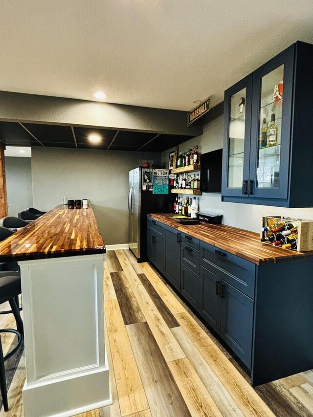 W330S8380 Isabelle Dr, Mukwonago, WI 53149 - bar with freestanding refrigerator, light wood-type flooring, baseboards, and a dry bar