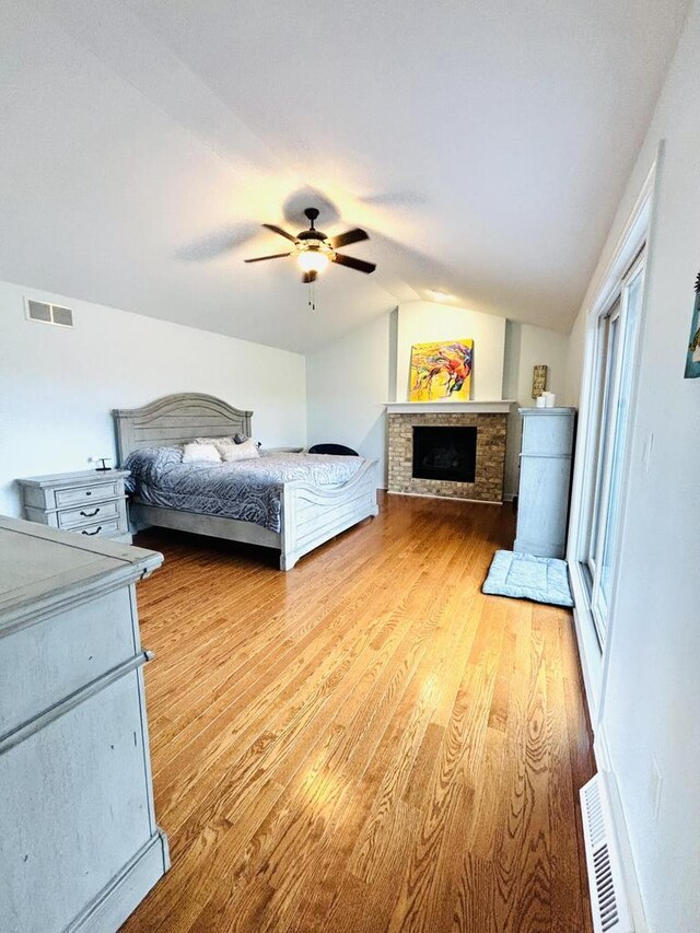 W330S8380 Isabelle Dr, Mukwonago, WI 53149 - bedroom featuring light wood-style flooring, a fireplace, lofted ceiling, and visible vents