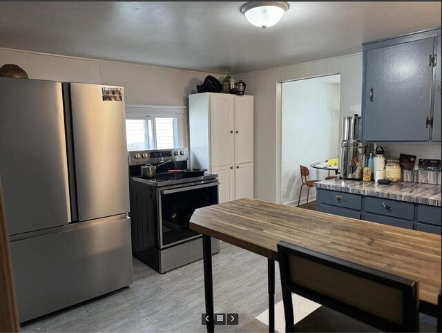 kitchen featuring stainless steel appliances, dark countertops, and gray cabinets