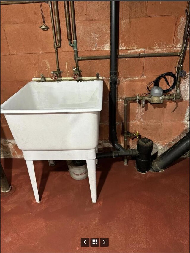 interior details with concrete flooring, a sink, and concrete block wall