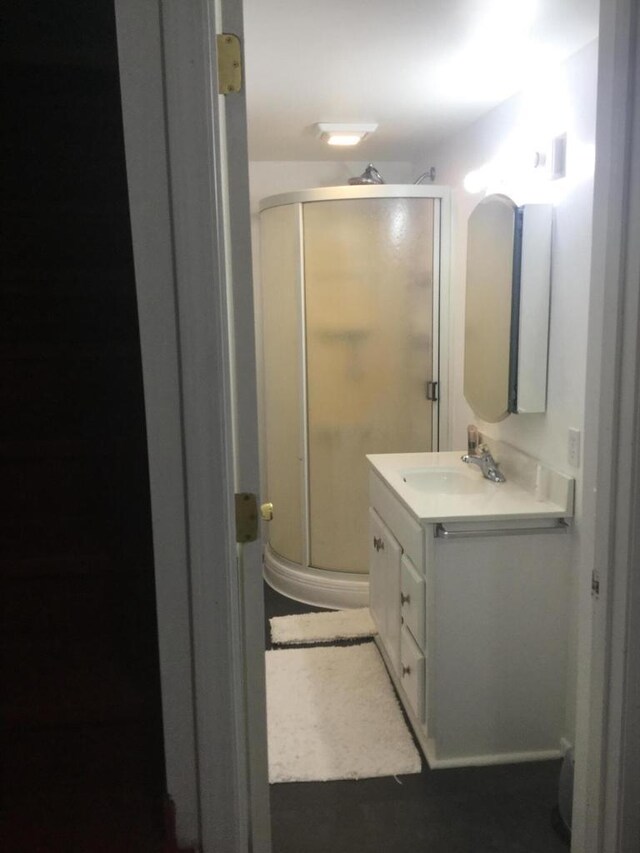 bathroom featuring a shower stall and vanity
