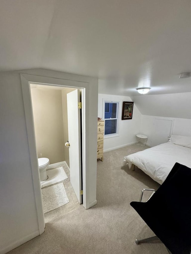 carpeted bedroom featuring baseboards and lofted ceiling