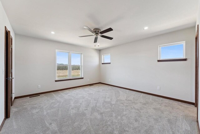 2465 Russell Ct, Reedsburg, WI 53959 - empty room with light carpet, visible vents, baseboards, and a ceiling fan