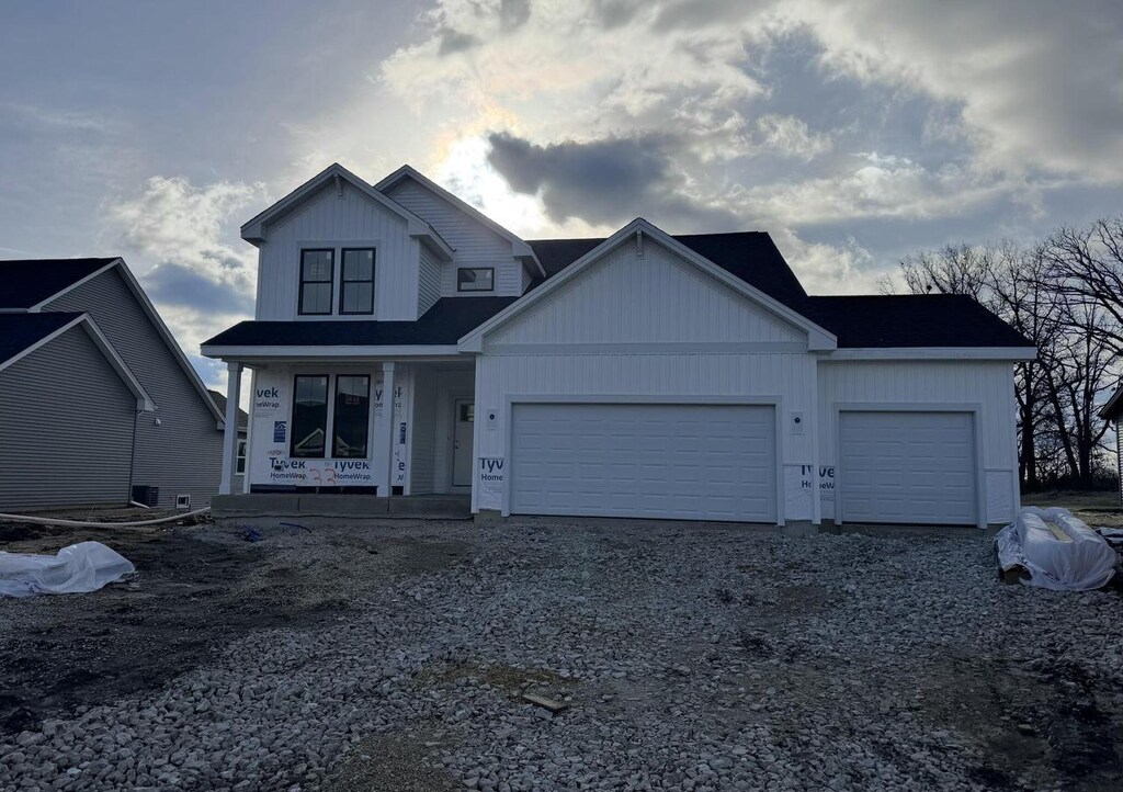 333 Kiddle Ln, Union Grove, WI 53182 - view of front of home featuring an attached garage, board and batten siding, driveway, and covered porch