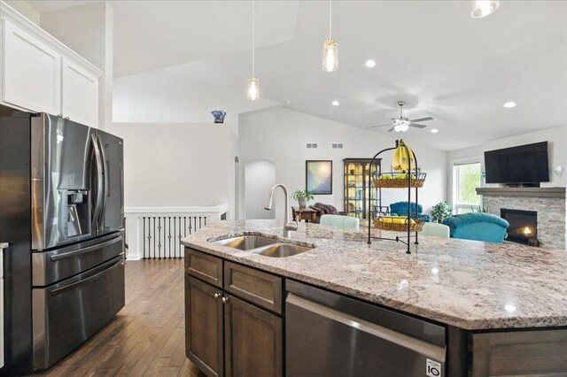kitchen featuring a sink, appliances with stainless steel finishes, lofted ceiling, and open floor plan