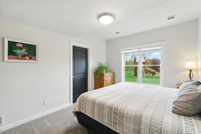 carpeted bedroom featuring baseboards and visible vents