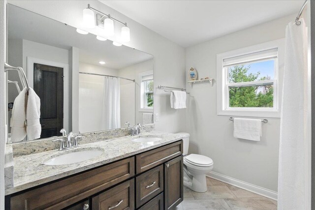 full bath with a sink, baseboards, and plenty of natural light