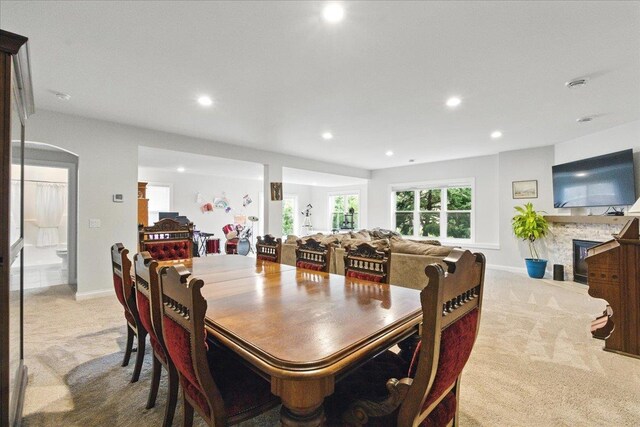 carpeted dining room with baseboards, a fireplace, and recessed lighting