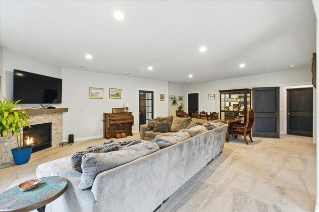 living room with recessed lighting, light colored carpet, and a fireplace