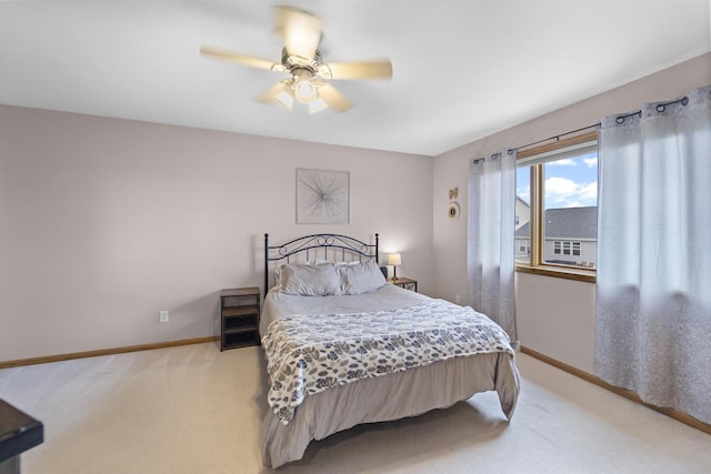 bedroom featuring light carpet, a ceiling fan, and baseboards