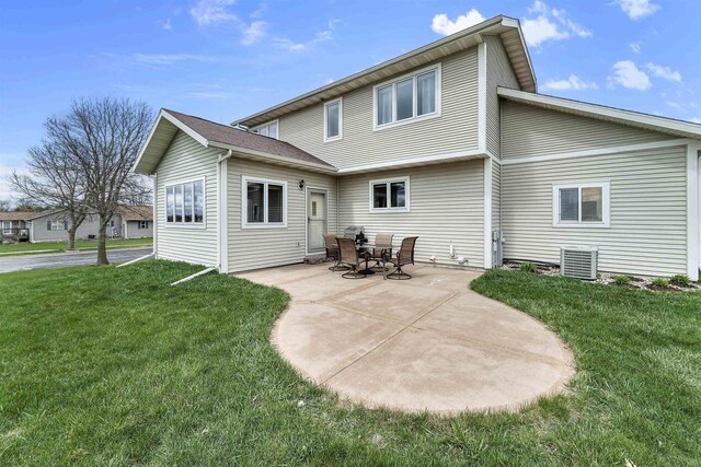 back of house with a yard and a patio