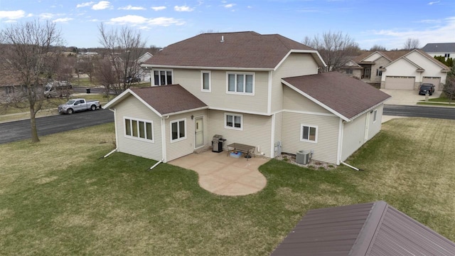 rear view of property featuring central AC, a shingled roof, and a lawn