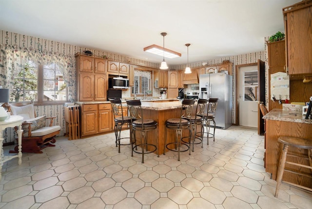 N5120 Summit Ct, Fond Du Lac, WI 54937 - kitchen featuring stainless steel fridge with ice dispenser, a center island, a kitchen breakfast bar, wallpapered walls, and light floors