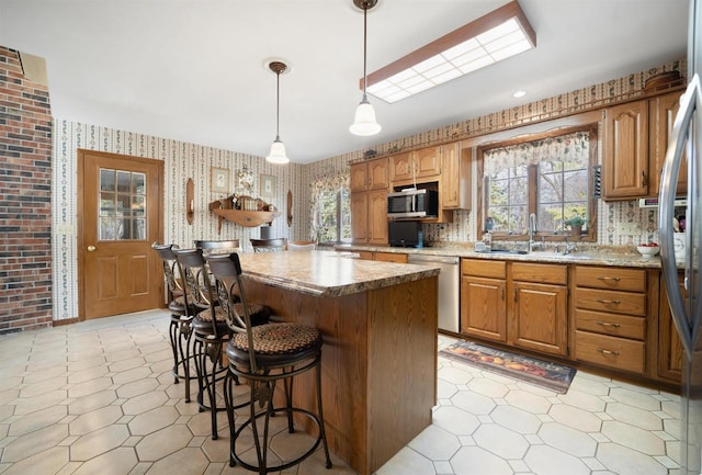 N5120 Summit Ct, Fond Du Lac, WI 54937 - kitchen featuring plenty of natural light, a sink, wallpapered walls, a kitchen island, and stainless steel appliances