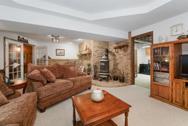 N5120 Summit Ct, Fond Du Lac, WI 54937 - carpeted living room with a wood stove, a raised ceiling, and brick wall
