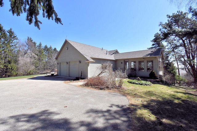 view of side of property with driveway and an attached garage