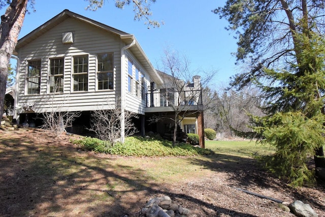 view of property exterior featuring a chimney and a wooden deck
