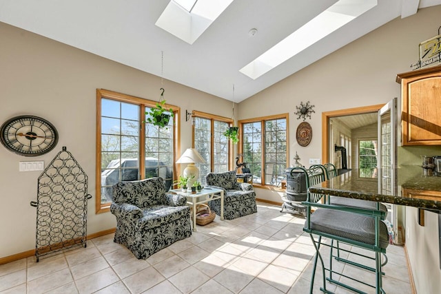 interior space featuring lofted ceiling with skylight, light tile patterned floors, and baseboards
