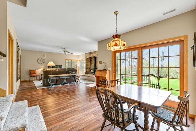 dining room with visible vents, ceiling fan, wood finished floors, and baseboards