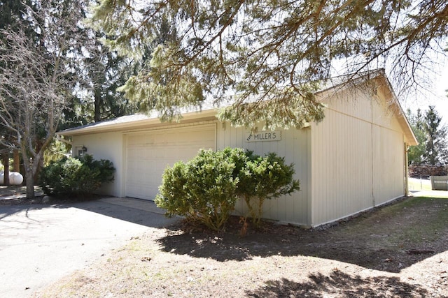view of side of property with driveway and an attached garage